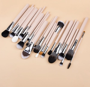 Flat lay of 24 professional makeup brushes with pink handles and silver ferrules