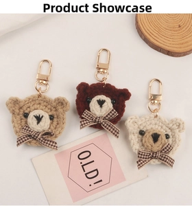 Close-up of three handmade crochet bear head keychains with plaid bows and metal clips