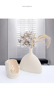 Detail of matte beige ceramic candle holder and vase with minimalist Nordic lighting