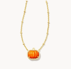 Macro detail van de gouden kralenketting en realistische oranje pompoenhanger met textuur