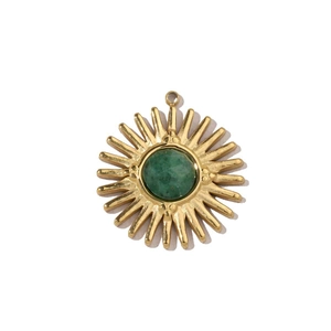 Detailed macro shot of a sunburst gold pendant with a round green gemstone center