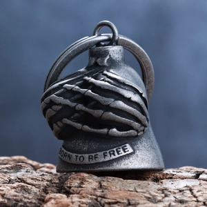 Macro shot of silver guardian bell with skull hand relief and Born to be Free engraving