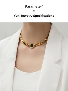 Close-up of golden chunky chain necklace with a black square pendant on a female model