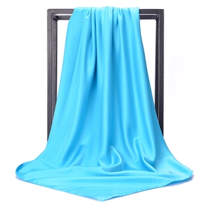 Detail view of bright blue satin scarf fabric showing smooth texture and elegant drape