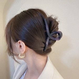 Matte acrylic large claw clip in deep purple grey with gold hoop earrings on model