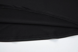 Détail de l'ourlet de la robe en dentelle noire montrant la couture et la texture du tissu