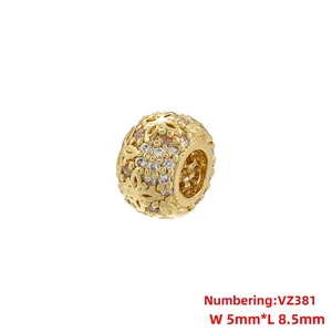 Macro detail of gold plated hollow flower charm bead with pink and clear cubic zirconia