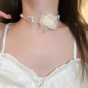 Three-layer faux pearl choker with a delicate white tulle flower on a female model