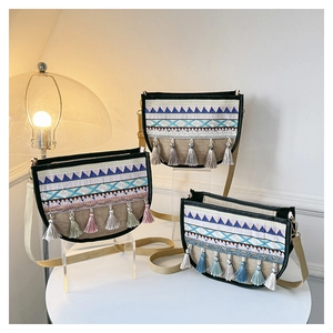 Detail of bohemian ethnic crossbody bags with geometric embroidery and tassel accents