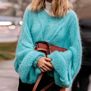 Detail of bright blue fluffy mohair knit texture on a loose fit round neck sweater