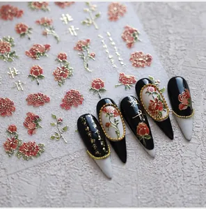 Détail de stickers à ongles mats avec motifs floraux dorés et calligraphie chinoise