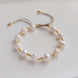 Stackable freshwater pearl and gold bead bracelet with adjustable beige woven cord