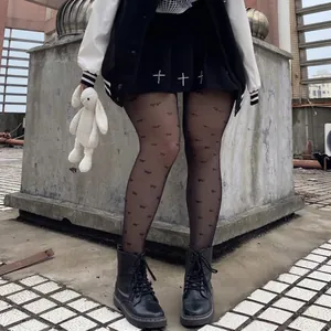 Sheer black pantyhose with butterfly print paired with skirt and boots in industrial setting