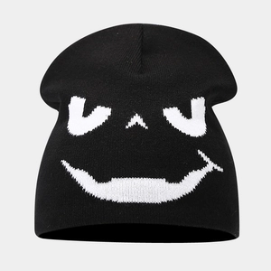 Close-up of black knitted beanie featuring white jacquard ghost face pattern for Halloween