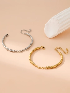 Detailed view of wave pendant beaded bracelets in gold and silver with lobster clasp