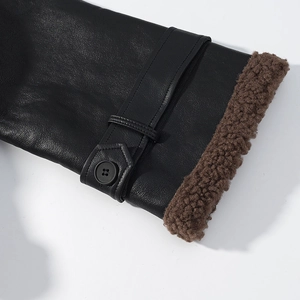 Detail shot of black leather sleeve cuff with coffee faux shearling lining and button