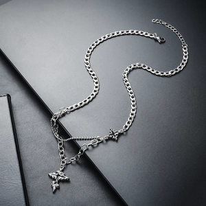 Close-up of double layer silver titanium steel necklace with cross pendant on black surface