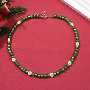 Detailed view of green pearl necklace with heart patterns on red festive background