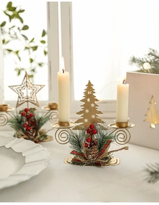 Close-up of golden metal Christmas tree double candle holder with pine needles and berries