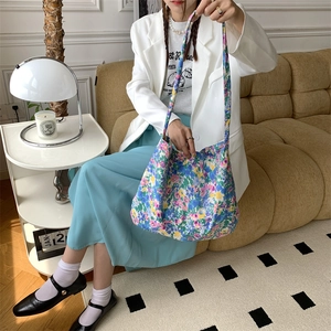 Floral canvas tote bag worn by a model in a minimalist home setting with natural lighting