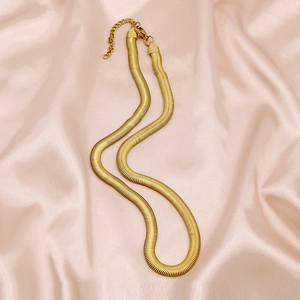 Polished 6mm gold snake chain necklace on silk background with lobster clasp