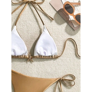 Conjunto de bikini blanco y bronce con dije de estrella de mar dorada y braga con lazos