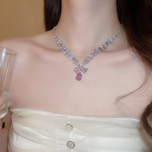 Close-up of elegant silver necklace featuring a pink pear-cut zircon pendant on model