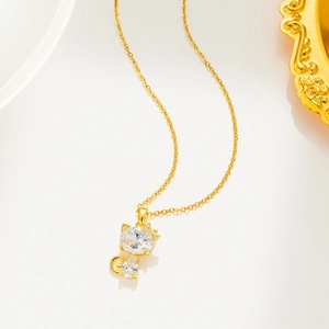 Macro shot of a gold cat pendant featuring a large clear zircon and micro-pave detailing
