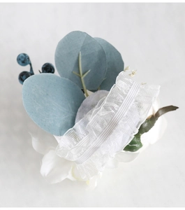 Close-up of white lace bridal wrist flower with elastic band and tulle texture