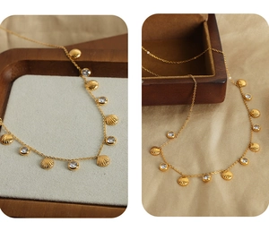 Macro detail of gold striped shell pendant with zirconia on premium satin and wood