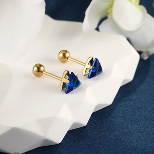 Detailed macro view of gold-plated triangle blue gemstone earrings with screw ball backs