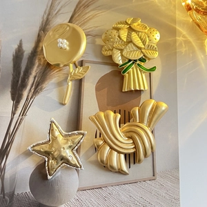 Gros plan de broches dorées et argentées mates aux motifs vintage de fleurs et d'étoiles