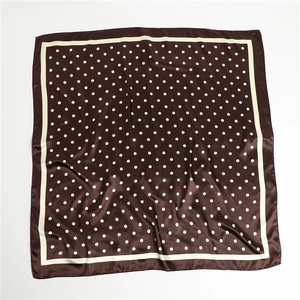 Detailed view of large square satin scarf with white polka dots on dark brown silk