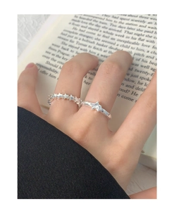 Close-up of S925 sterling silver star rings with pleated texture on open book pages