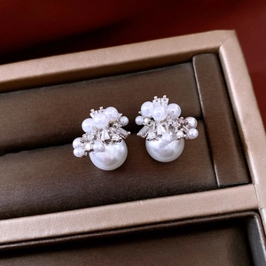Detail of 18K gold plated pearl stud earrings with sparkling cubic zirconia clusters
