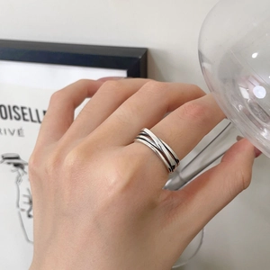 Macro detail of silver S925 multilayer wrap ring showing modern intertwined band style
