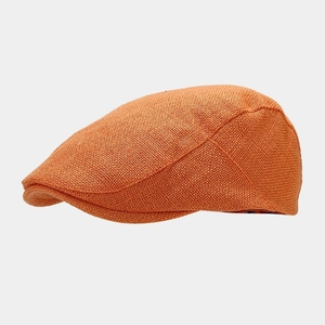 Detail of an orange knitted duckbill cap showing fine mesh texture and retro british style