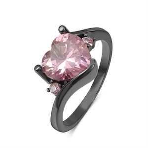 Macro view of heart-cut pink zircon center stone on a black plated crisscross ring