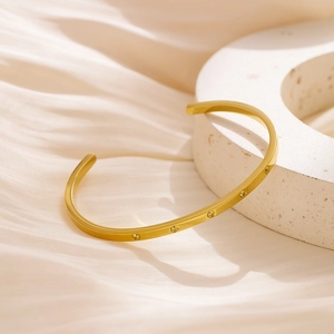 Macro detail of 18k gold plated stainless steel cuff bracelet with clear cubic zirconia