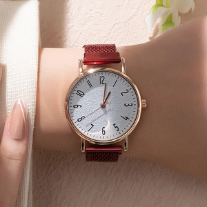 Elegant gold quartz watch with white textured dial and red magnetic mesh strap on wrist