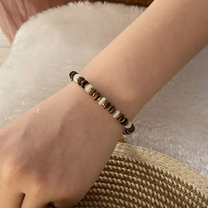 Maillard style tiger eye and cat eye heart bead bracelet on a soft plush background