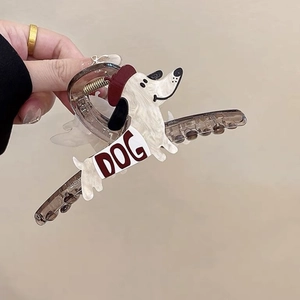 Detail shot of a cream-white acrylic dog-shaped hair claw clip with burgundy accents
