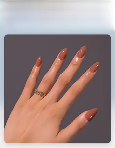 Glossy caramel brown almond-shaped press-on nails shown with gold rhinestone ring detail