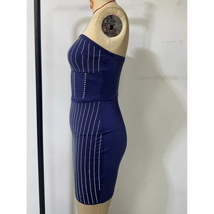 Detail of navy blue bodycon dress with vertical rhinestone stripes on a mannequin