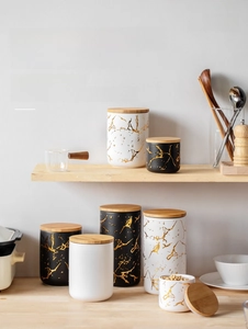 Macro detail of Nordic marble pattern ceramic jars with airtight wooden lids and silicone seal