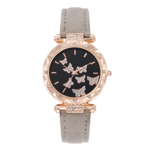 Detail of rose gold watch case with rhinestone bezel and black dial with butterfly motifs