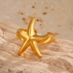 Golden irregular molten lava starfish open ring with polished metallic finish on sand