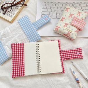 Detail of quilted fabric notebook covers with cute bows and metal snap closure