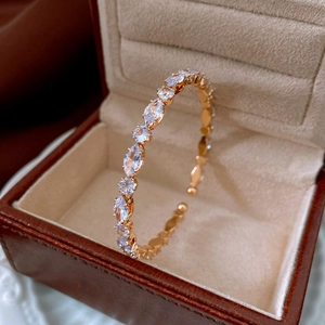 Close-up of rose gold open cuff bracelet with marquise and round zircon in a box