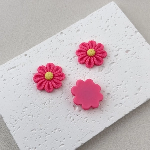 Detailed macro view of pink resin flower charms for DIY phone cases and craft projects